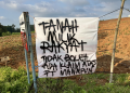 Banner yang ditancapkan warga Karangsari, Pati di lahan yang diklaim PT Rumpun Sari Antan pada Kamis, (14/5). (Bahtiar Yusuf/Arena)