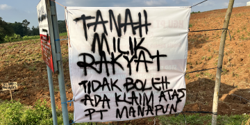 Banner yang ditancapkan warga Karangsari, Pati di lahan yang diklaim PT Rumpun Sari Antan pada Kamis, (14/5). (Bahtiar Yusuf/Arena)